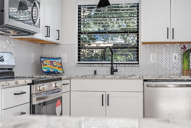 kitchen with white cabinets, a healthy amount of sunlight, and appliances with stainless steel finishes