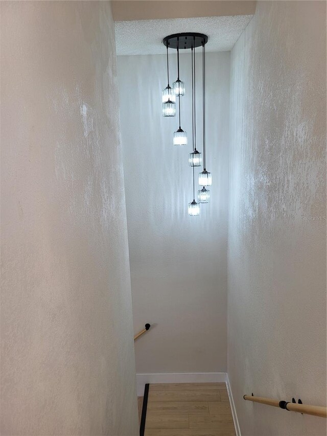 stairway featuring a textured ceiling and hardwood / wood-style flooring