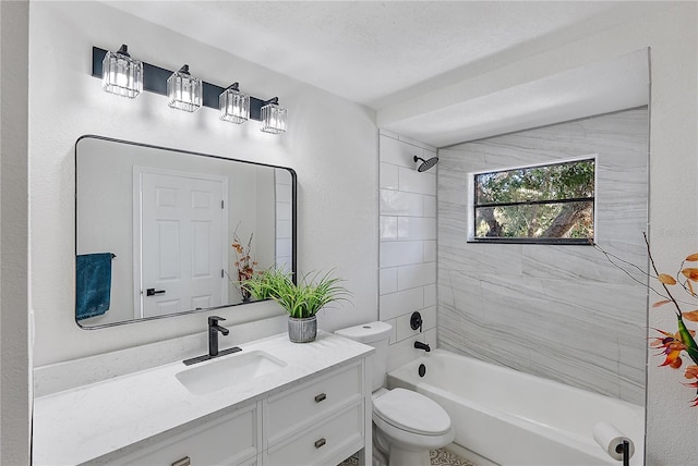 full bathroom featuring a textured ceiling, vanity, tiled shower / bath combo, and toilet