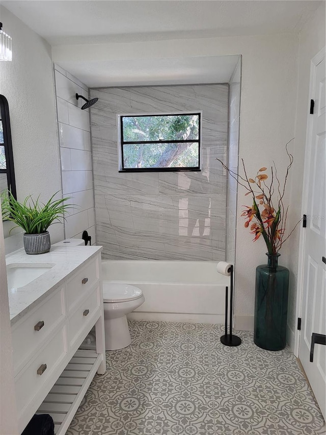 full bathroom featuring vanity, tiled shower / bath combo, and toilet