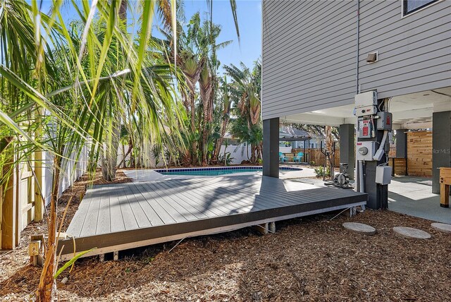 wooden deck with a fenced in pool