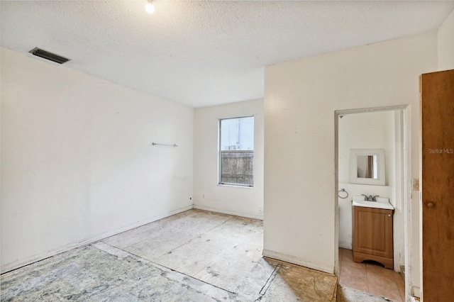 spare room with sink and a textured ceiling