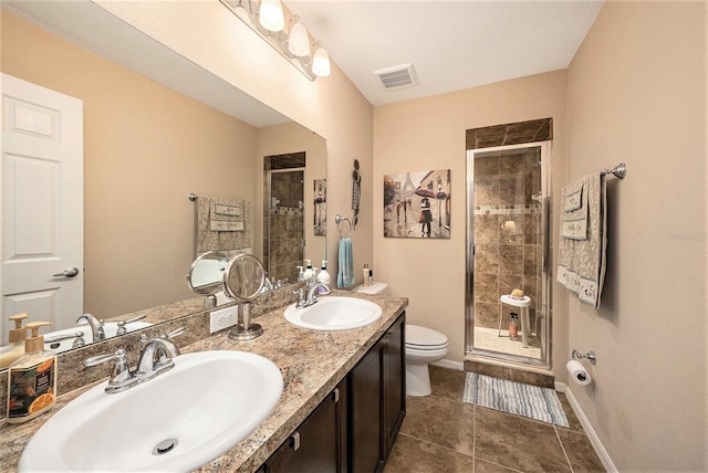 bathroom featuring tile patterned floors, vanity, toilet, and an enclosed shower