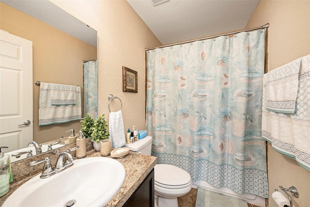 bathroom with vanity, a textured ceiling, and toilet