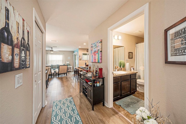 hallway with light hardwood / wood-style flooring and sink