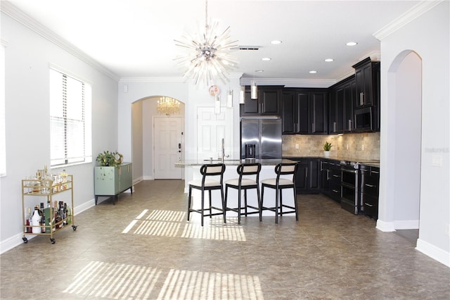 kitchen featuring a center island, stainless steel appliances, an inviting chandelier, a breakfast bar area, and ornamental molding