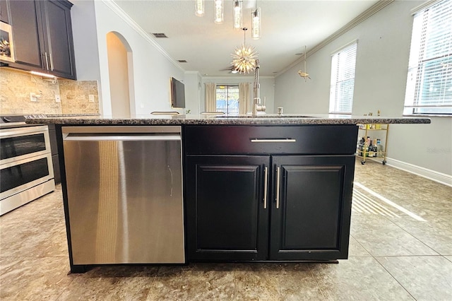 kitchen with a healthy amount of sunlight, ornamental molding, and stainless steel appliances