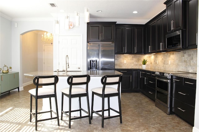 kitchen featuring hanging light fixtures, a center island with sink, stainless steel appliances, and sink