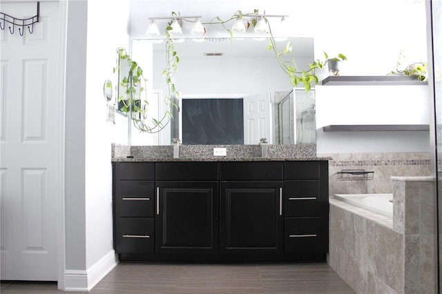 bathroom featuring vanity and independent shower and bath