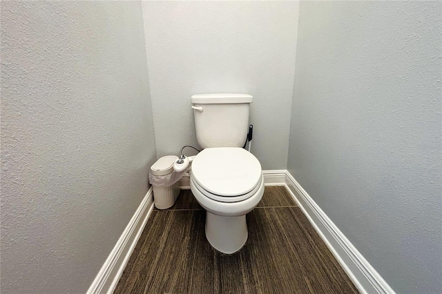 bathroom with hardwood / wood-style flooring and toilet