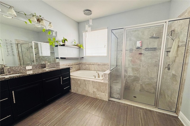 bathroom with hardwood / wood-style flooring, vanity, and plus walk in shower