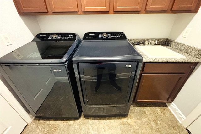 laundry room featuring washer and clothes dryer, cabinets, and sink