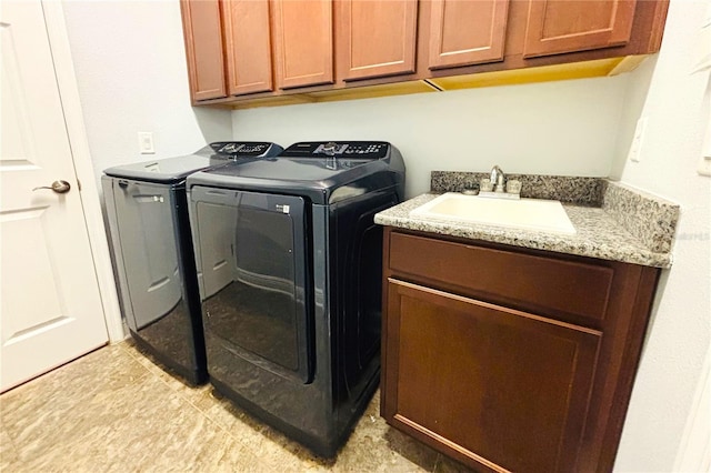 washroom with cabinets, separate washer and dryer, and sink