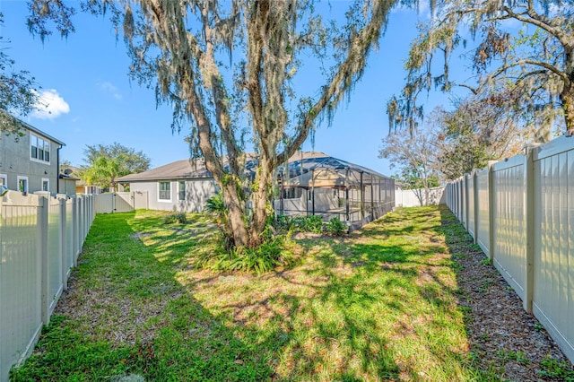 view of yard with a lanai and a fenced backyard