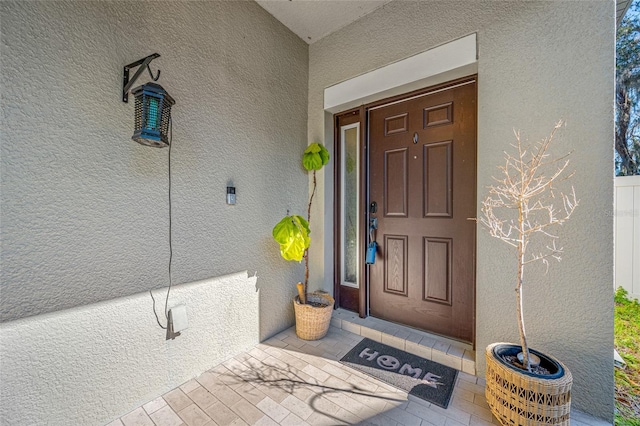 entrance to property with stucco siding