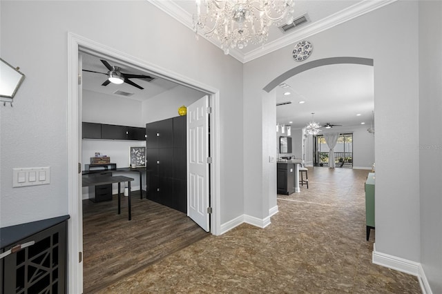 corridor featuring arched walkways, visible vents, crown molding, and baseboards