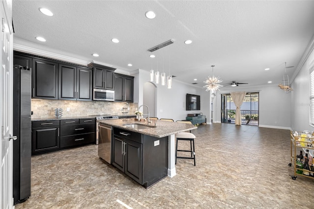 kitchen featuring a breakfast bar, a sink, visible vents, appliances with stainless steel finishes, and tasteful backsplash