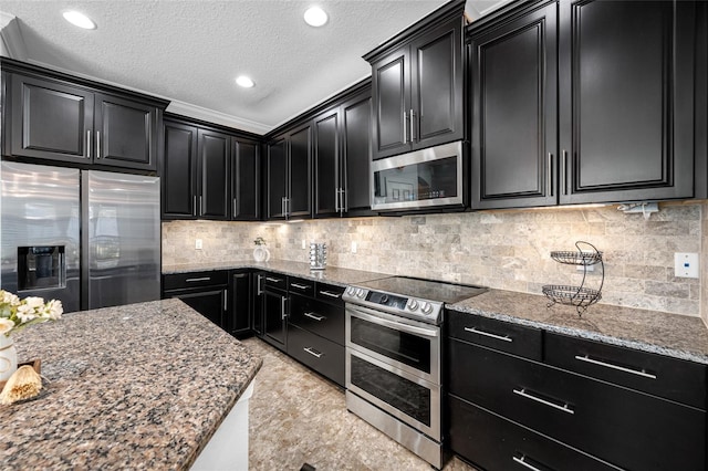 kitchen with stainless steel appliances, dark cabinets, and decorative backsplash