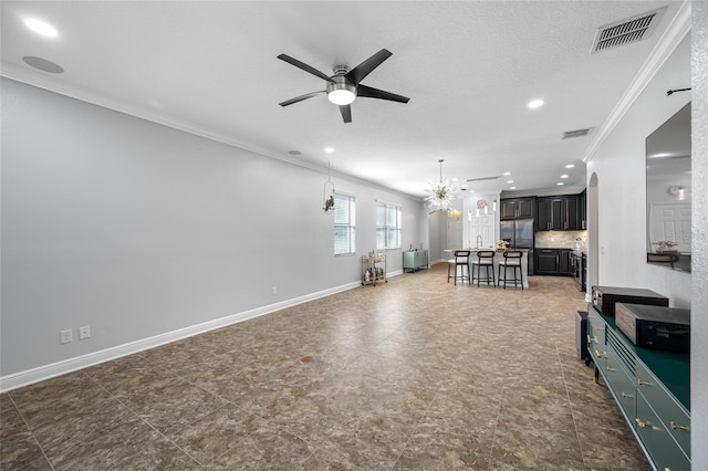 unfurnished living room with baseboards, visible vents, ceiling fan with notable chandelier, crown molding, and recessed lighting