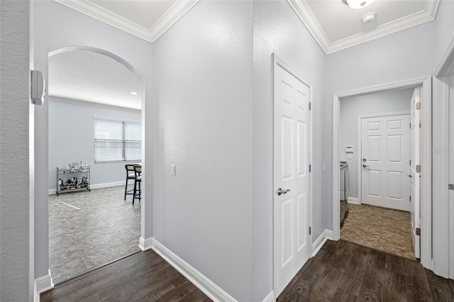 hallway with ornamental molding, arched walkways, dark wood-style flooring, and baseboards