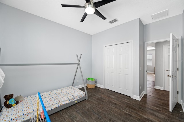 bedroom with baseboards, a closet, visible vents, and wood finished floors