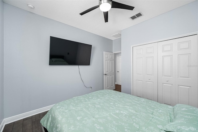 bedroom featuring dark wood finished floors, a closet, visible vents, a ceiling fan, and baseboards