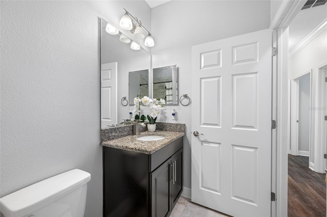 bathroom with baseboards, visible vents, vanity, and toilet