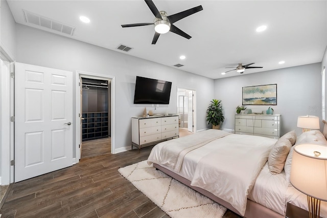 bedroom featuring dark wood-style floors, recessed lighting, a walk in closet, and visible vents