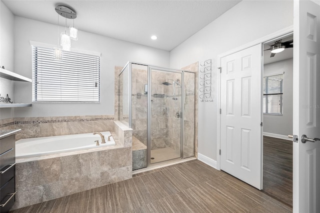 bathroom featuring baseboards, a shower stall, a bath, and a ceiling fan