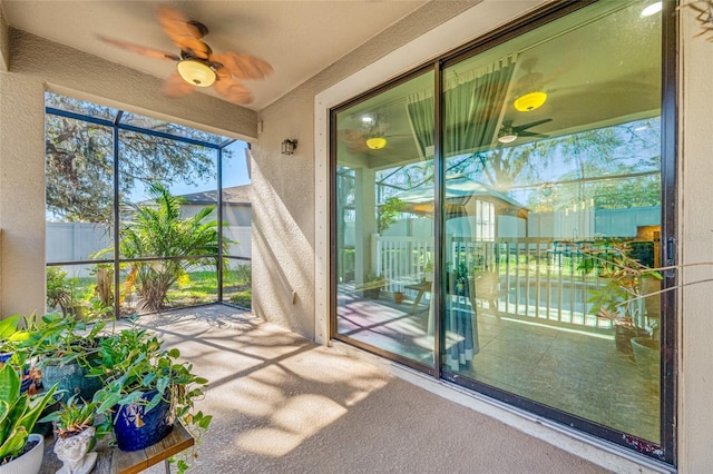 unfurnished sunroom with a ceiling fan