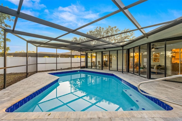 view of swimming pool featuring glass enclosure and a patio area