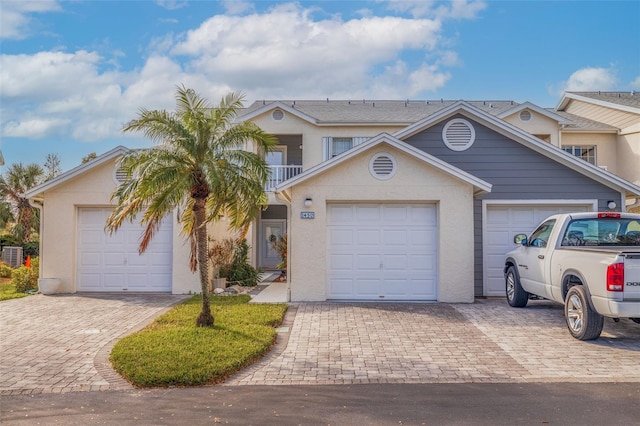 view of front of property featuring a garage and a balcony