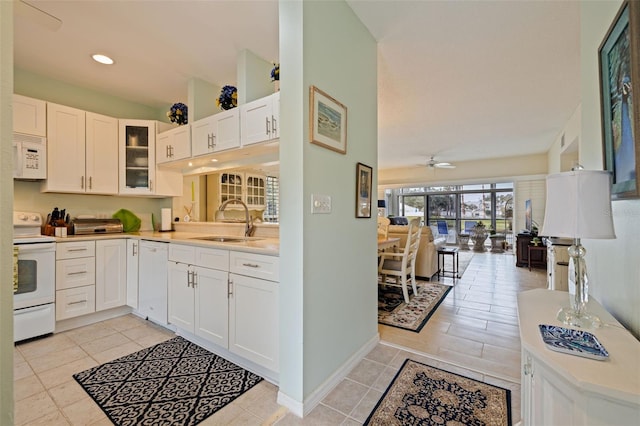 kitchen featuring white appliances, white cabinetry, ceiling fan, and sink