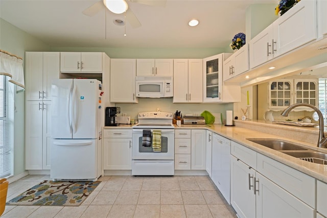 kitchen featuring light tile patterned floors, white appliances, white cabinetry, and sink