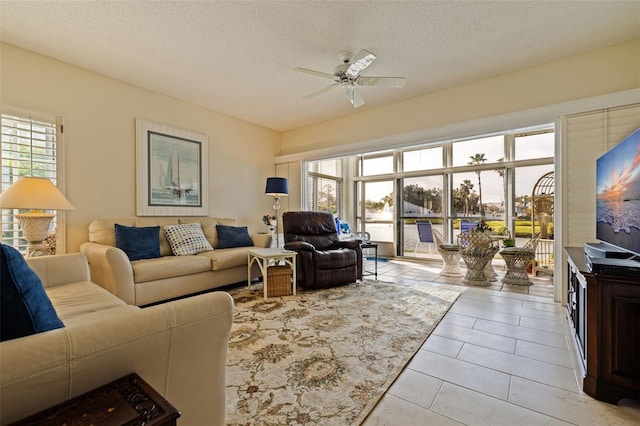 tiled living room featuring ceiling fan and a textured ceiling