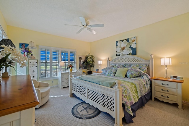 carpeted bedroom featuring a textured ceiling and ceiling fan