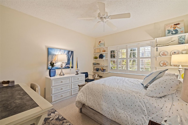 carpeted bedroom with a textured ceiling and ceiling fan