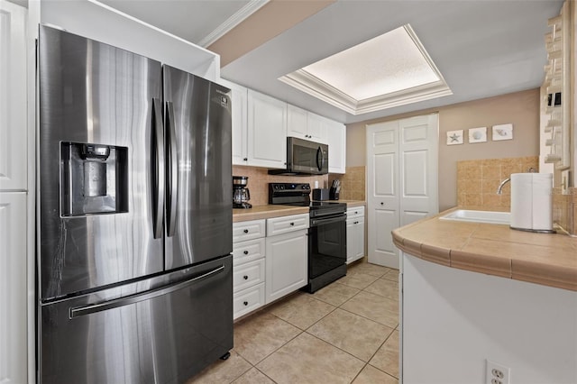 kitchen featuring appliances with stainless steel finishes, tasteful backsplash, ornamental molding, white cabinetry, and light tile patterned flooring