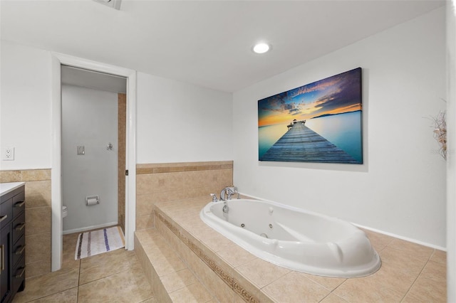 bathroom featuring tile patterned flooring, vanity, and tiled tub