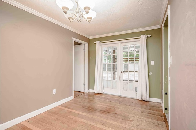 interior space featuring a textured ceiling, ornamental molding, a notable chandelier, and light wood-type flooring