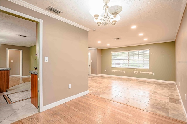 spare room featuring a chandelier, crown molding, a textured ceiling, and light hardwood / wood-style flooring