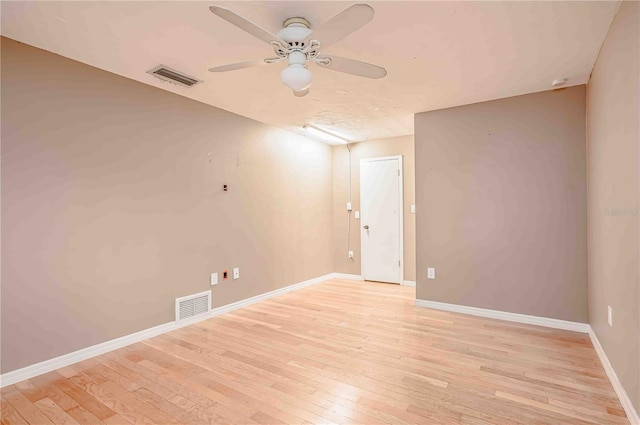 empty room with ceiling fan and light hardwood / wood-style flooring