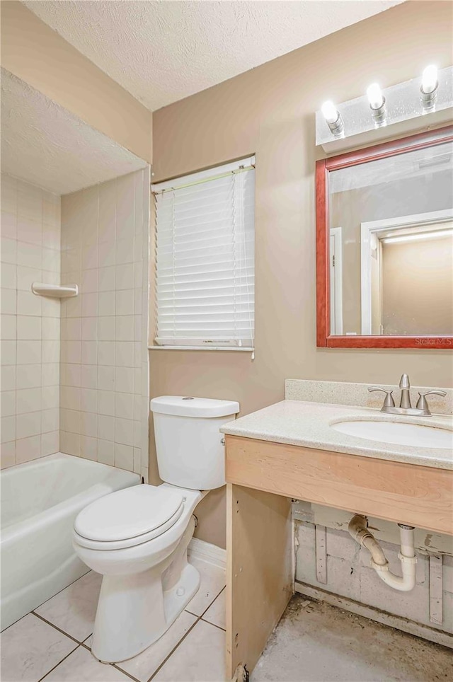 full bathroom with sink, tile patterned flooring, a textured ceiling, toilet, and tiled shower / bath