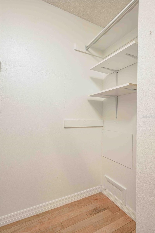 spacious closet featuring light hardwood / wood-style flooring