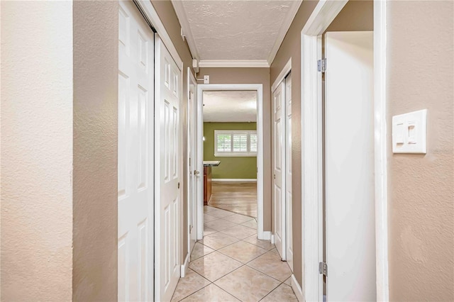 hallway featuring ornamental molding and light tile patterned floors