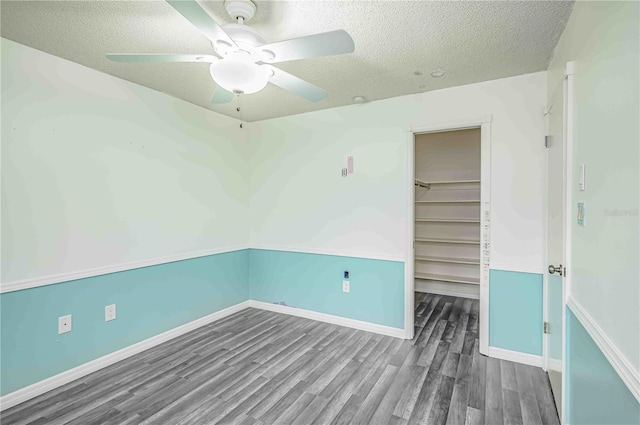 unfurnished room featuring ceiling fan, wood-type flooring, and a textured ceiling