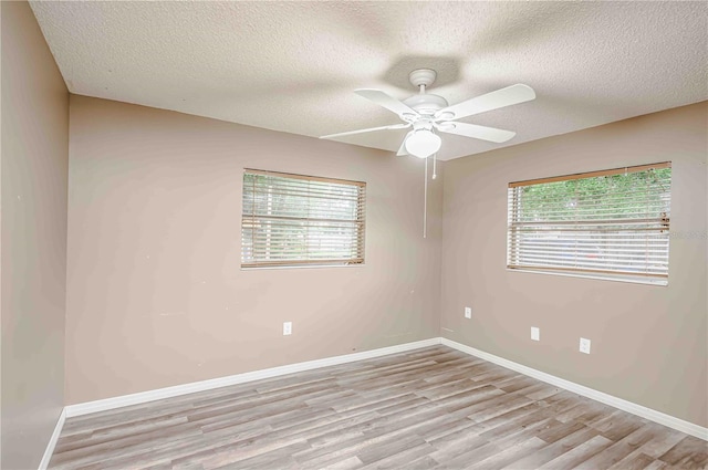 empty room featuring ceiling fan, a textured ceiling, and light hardwood / wood-style flooring