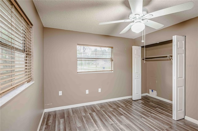 unfurnished bedroom featuring a closet, a textured ceiling, light hardwood / wood-style floors, and ceiling fan