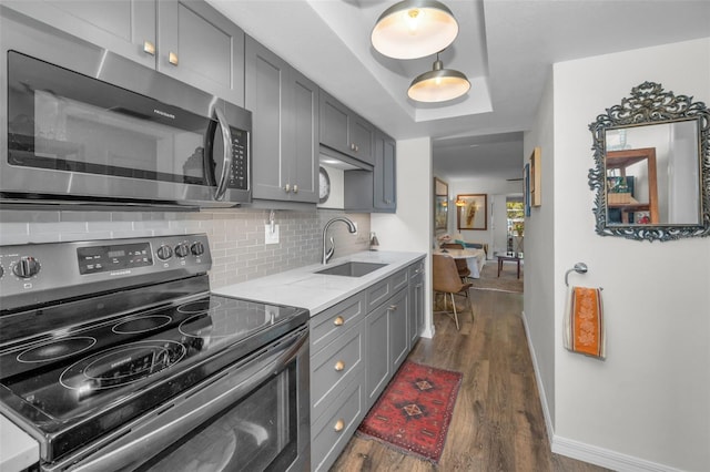 kitchen with gray cabinetry, sink, dark wood-type flooring, black range with electric cooktop, and decorative backsplash