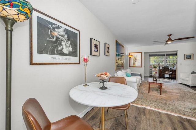 dining area with ceiling fan and wood-type flooring